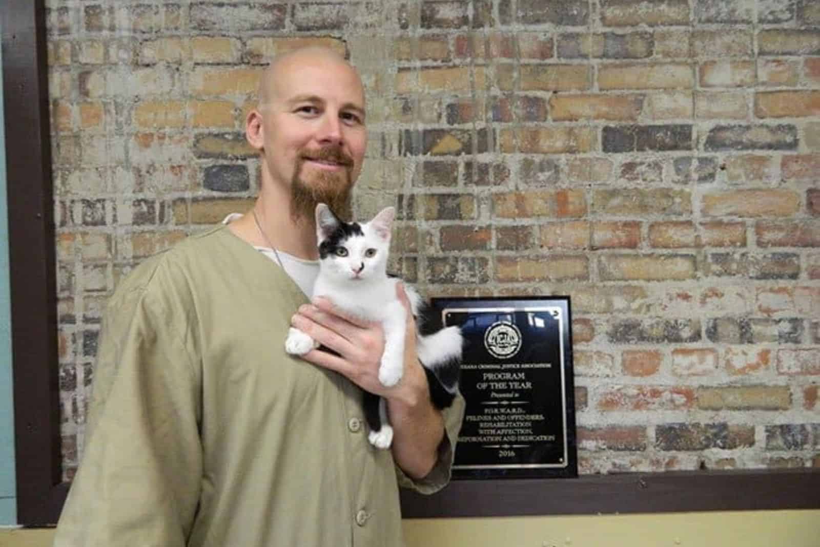 Guy holding black and white cat