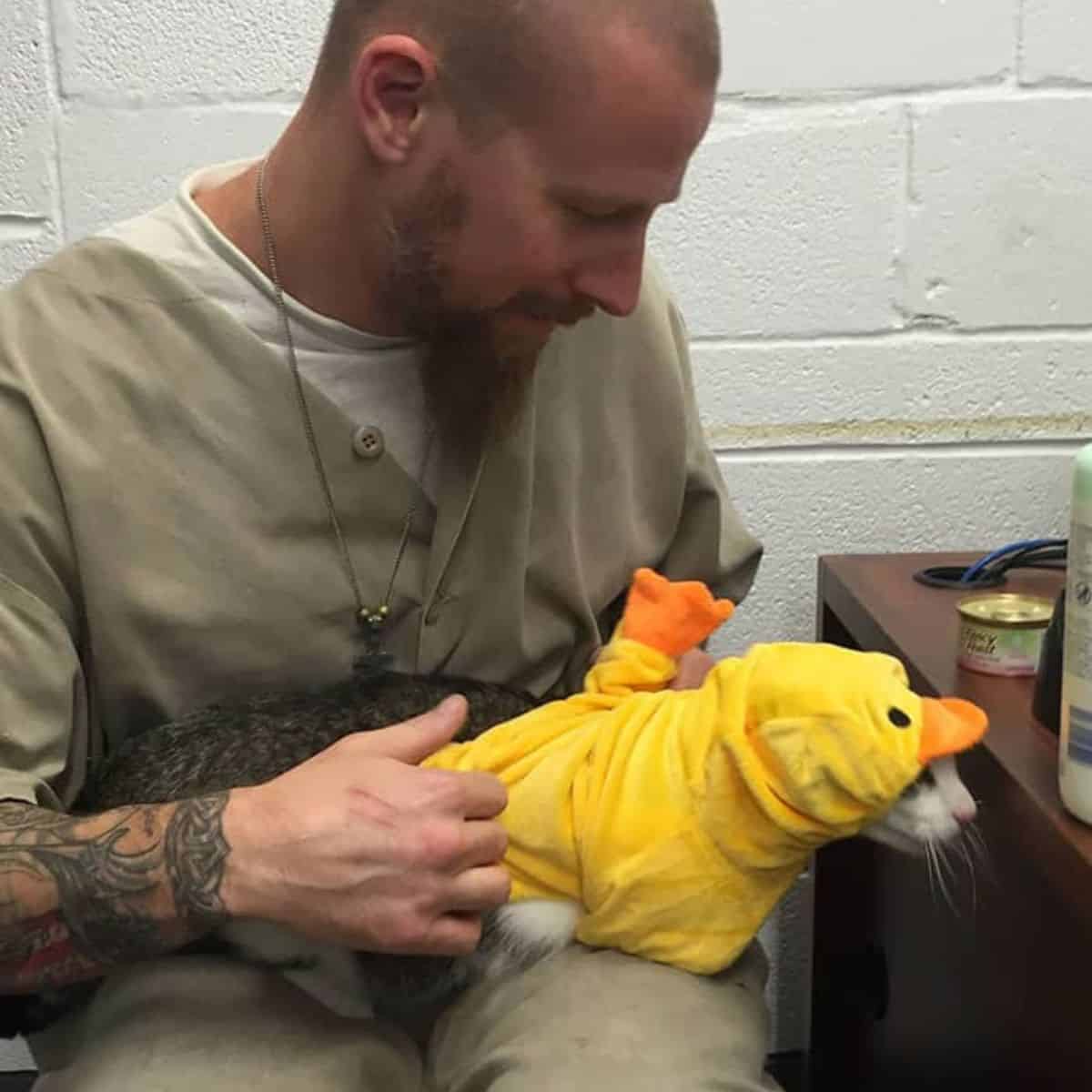 Man with beard and tatoos holding a cat