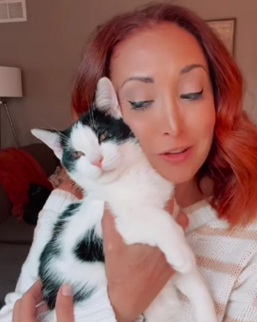 a girl holds a cat with Cerebellar Hypoplasia in her arms