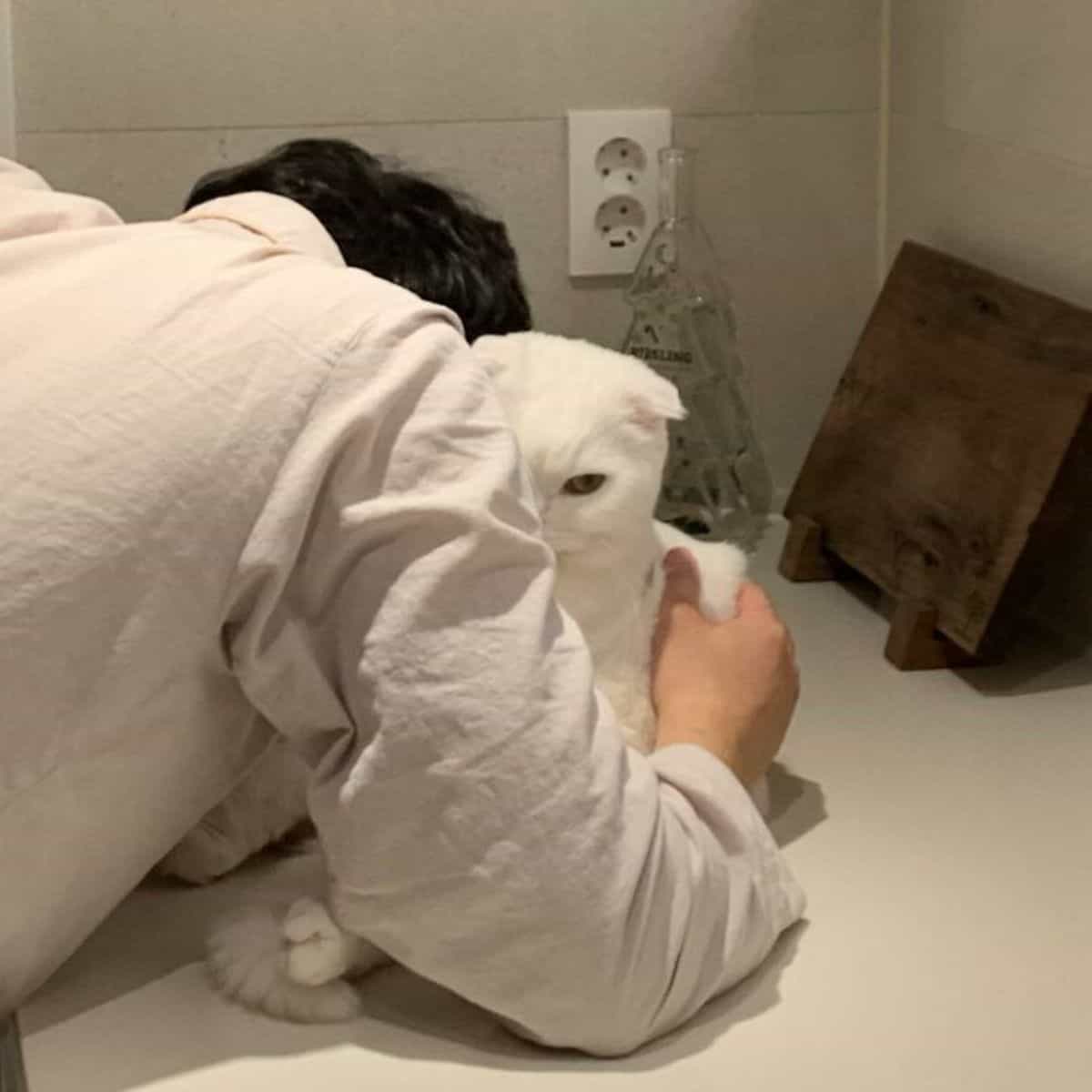 a man hugs a cat on the kitchen table