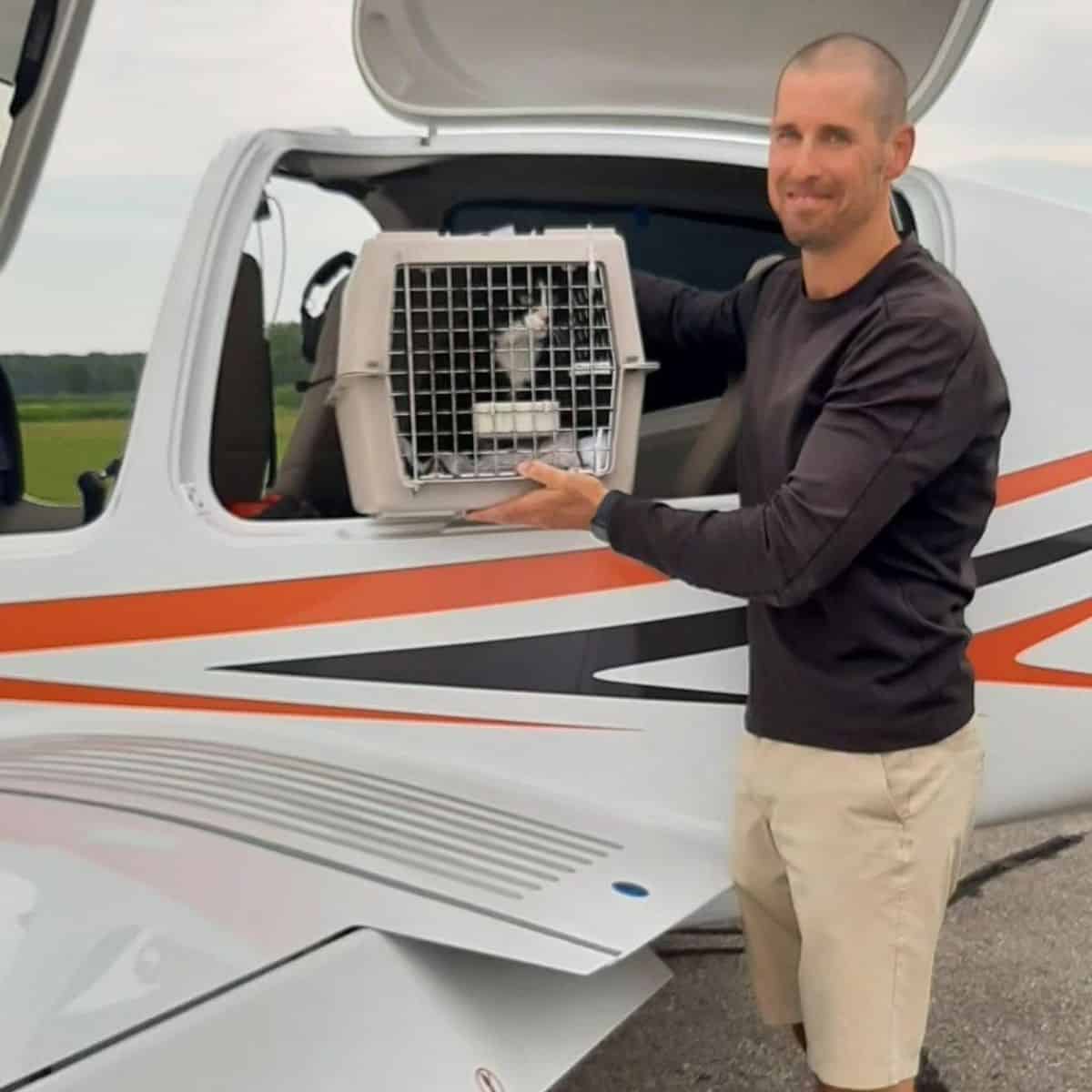 guy holding the cat cage