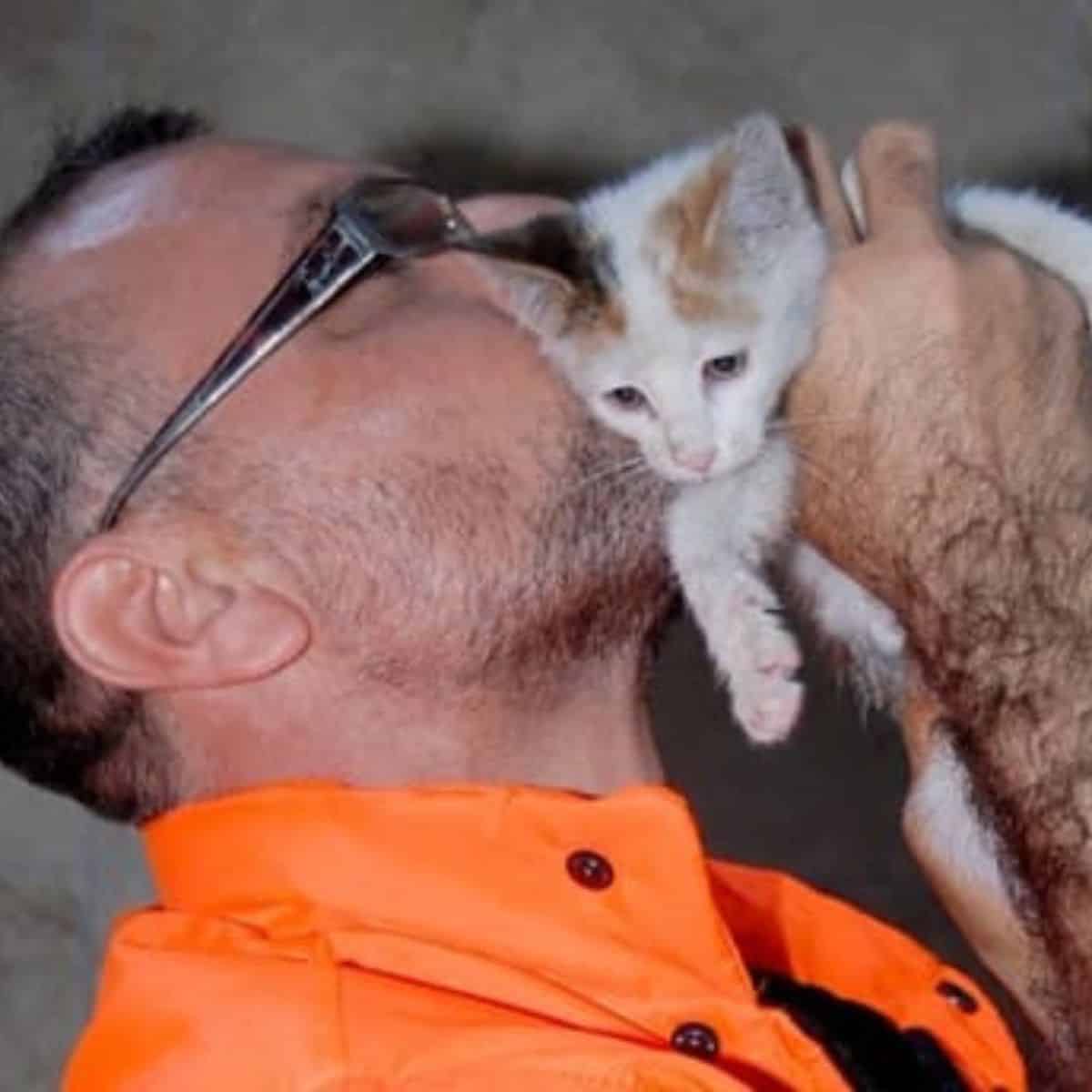 man kissing kitten