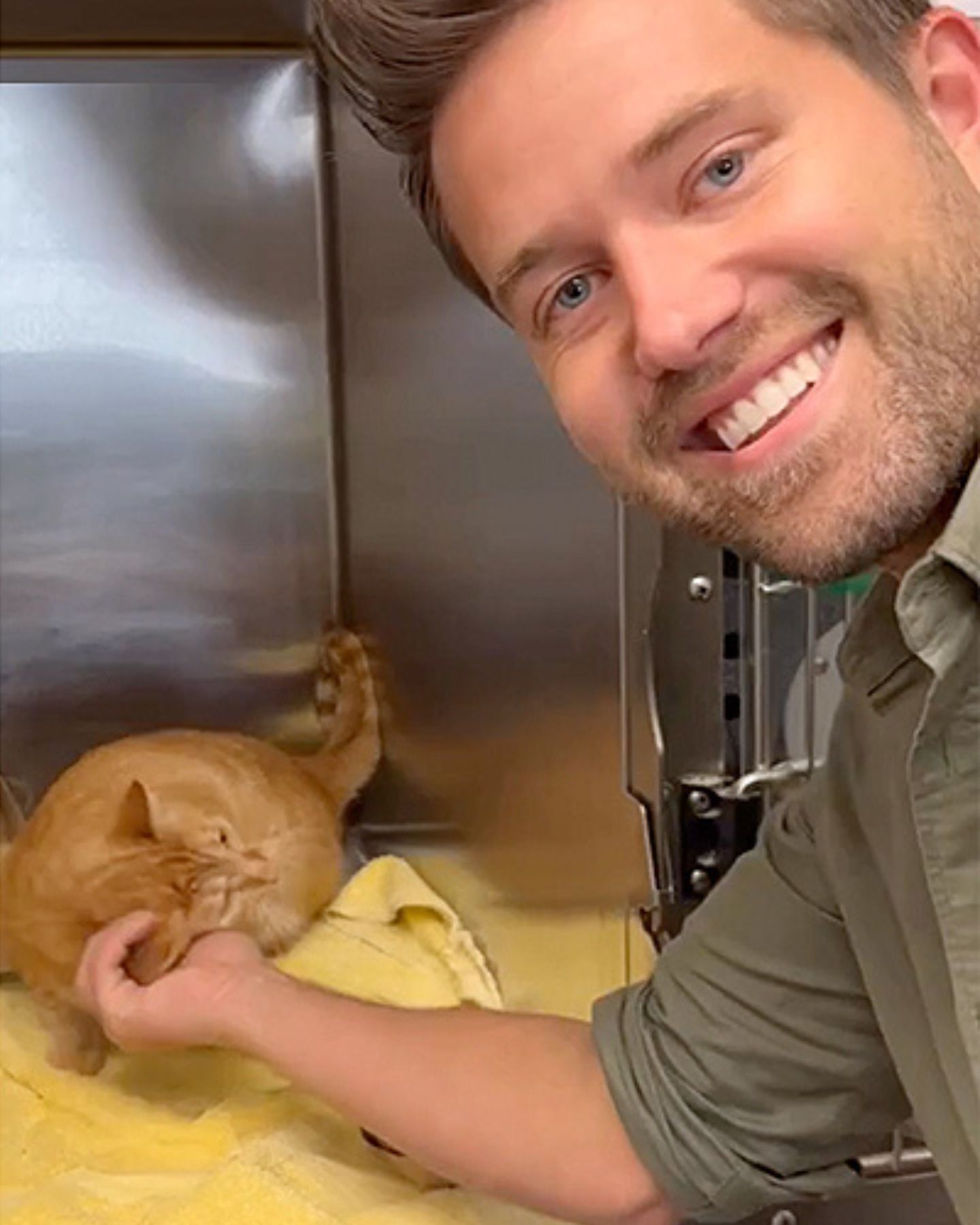 smiling man with ginger cat posing