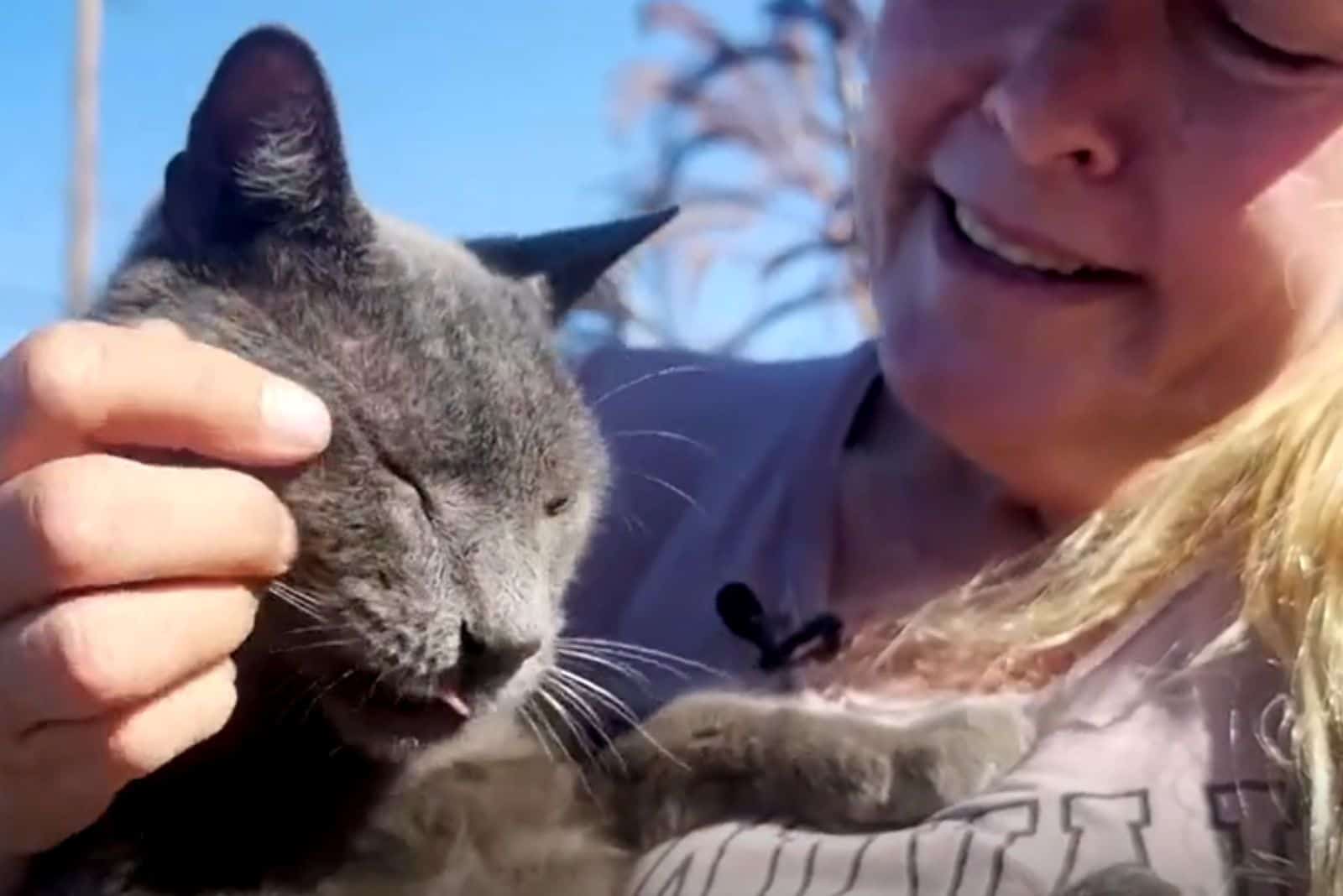 smiling woman carresing the cat