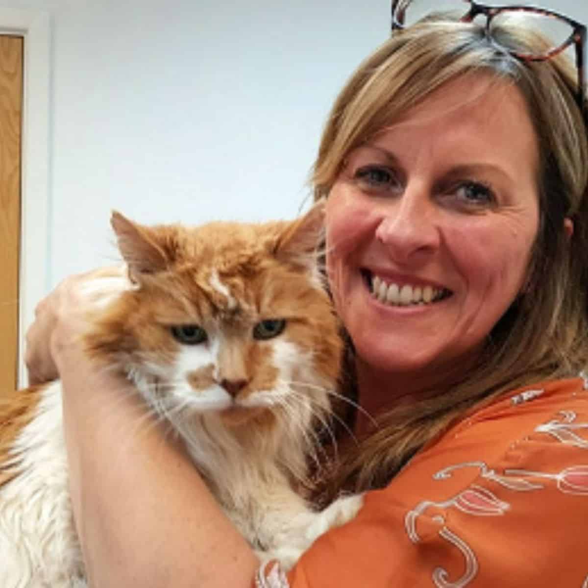 smiling woman holding a cat