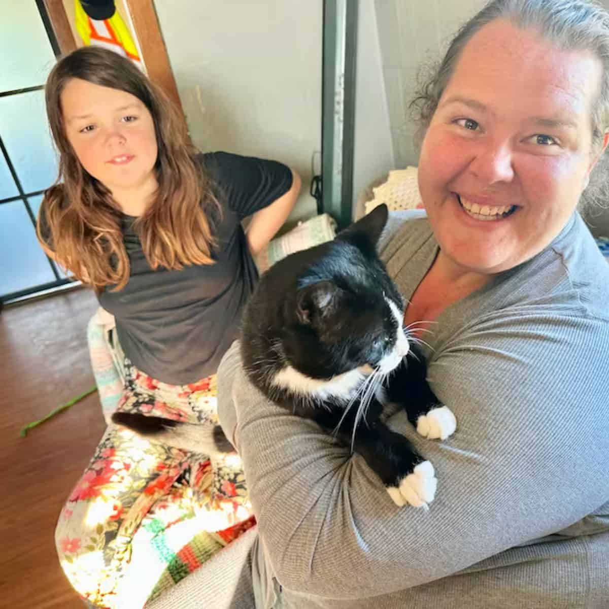 two girls holding the cat