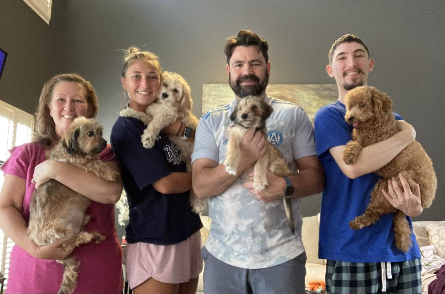 two woman and two man each holding a dog