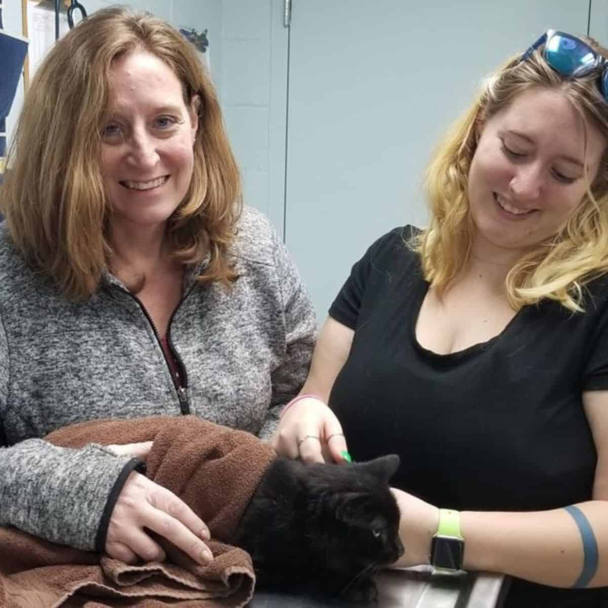 two women with a cat