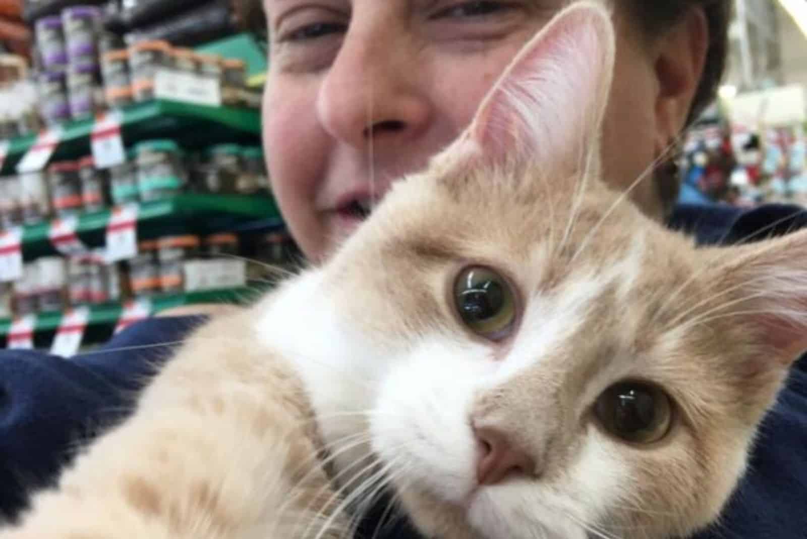 woman holding a ginger cat