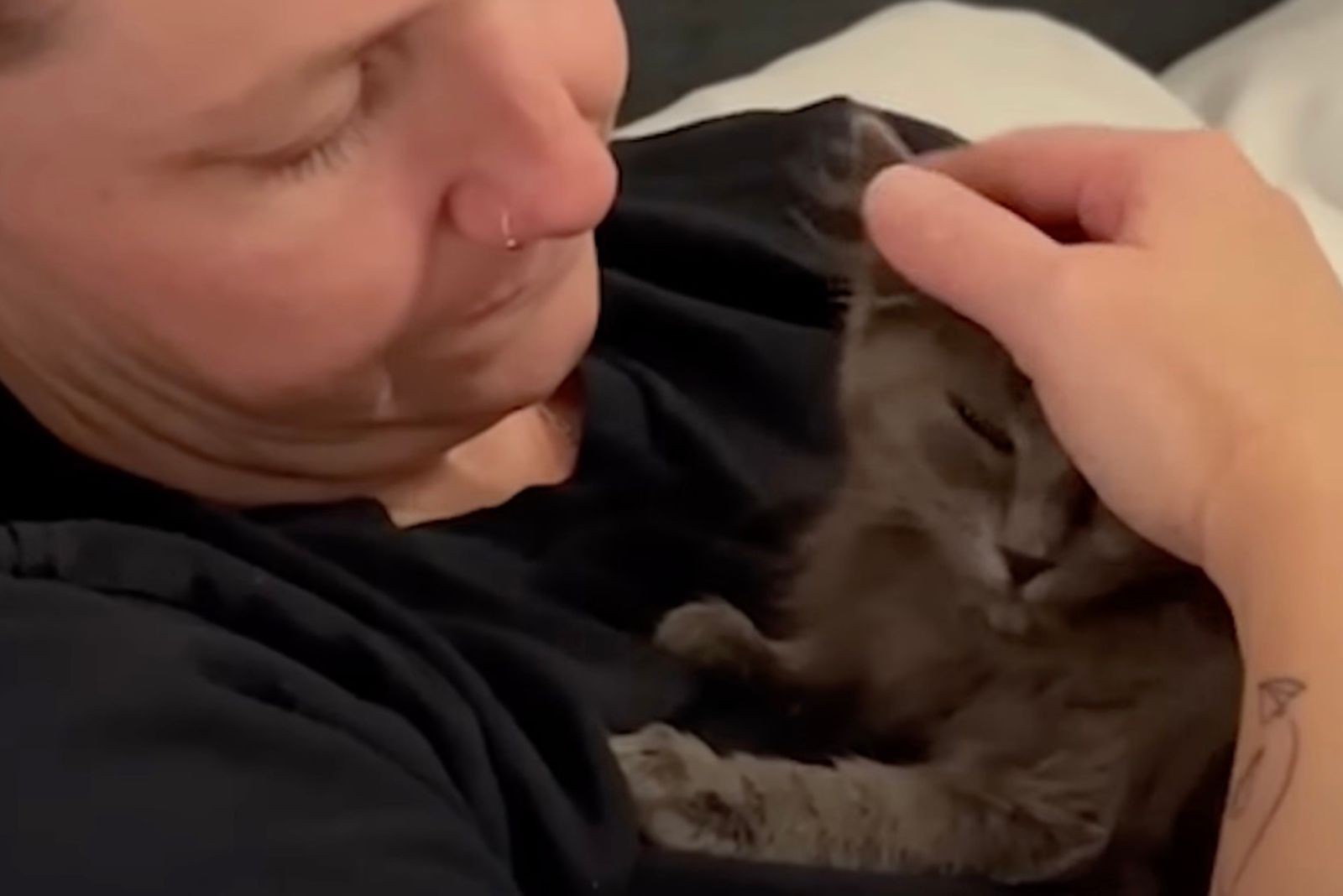 woman holding cat on her chest