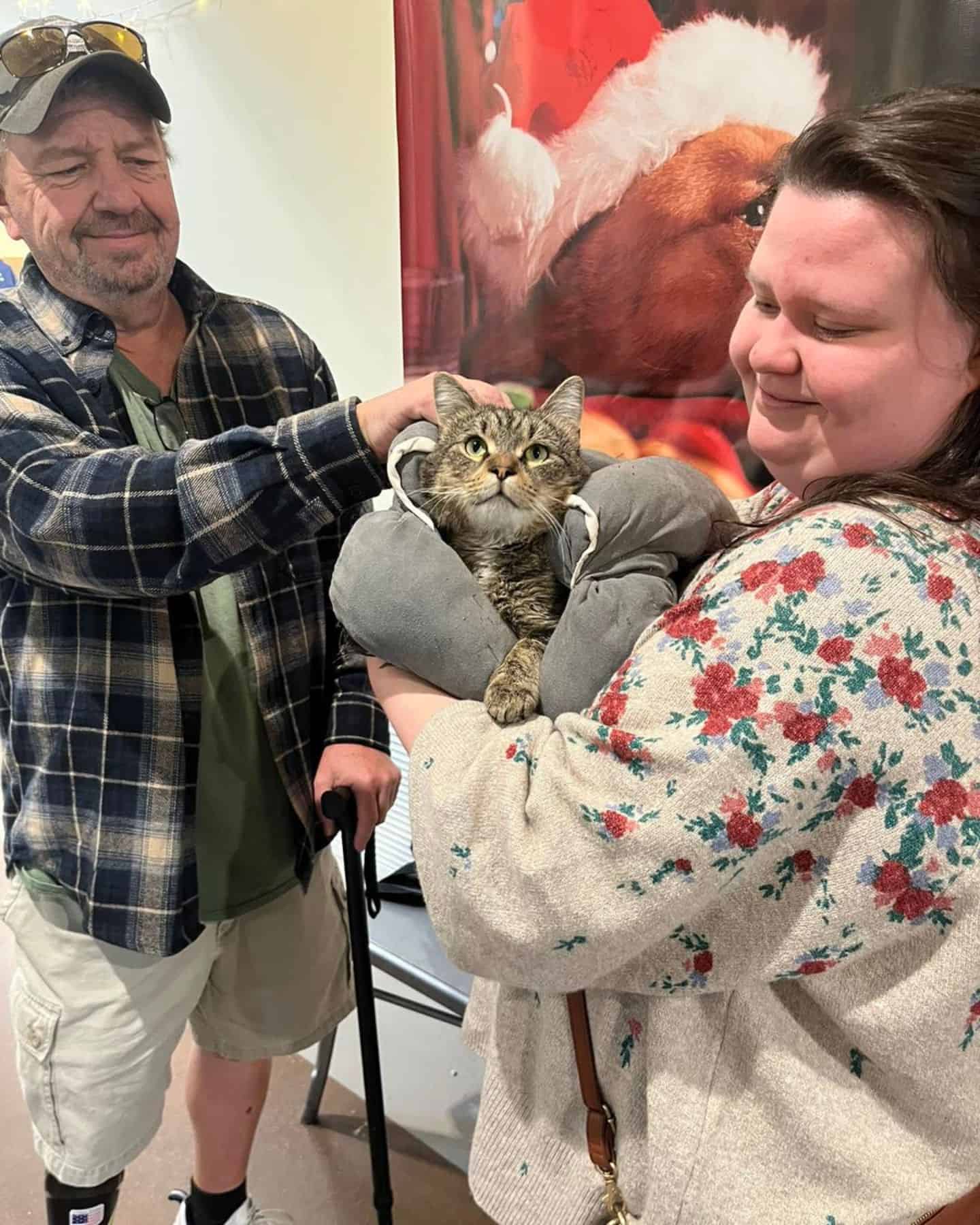 woman holding three-legged cat