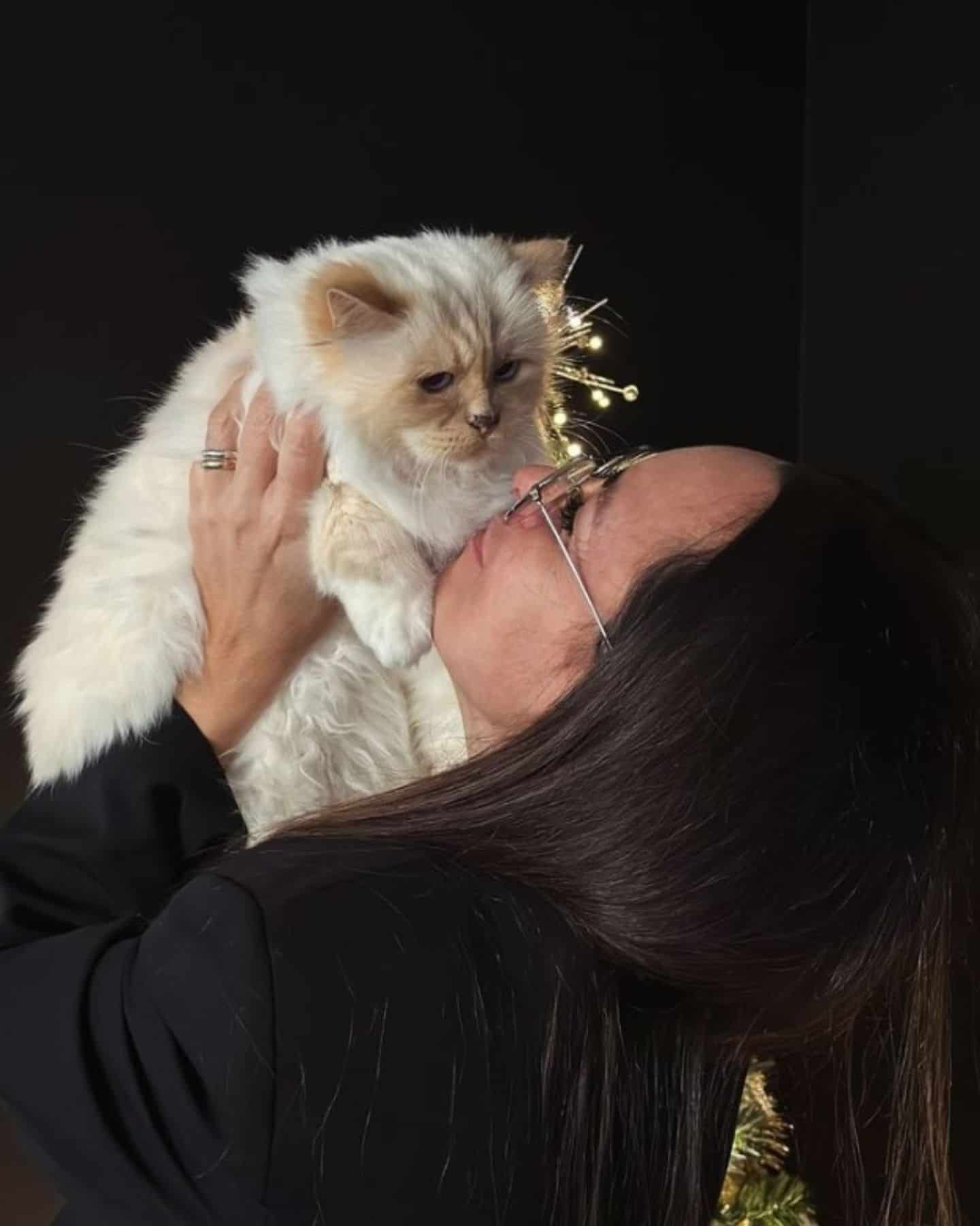 woman holding up a cat