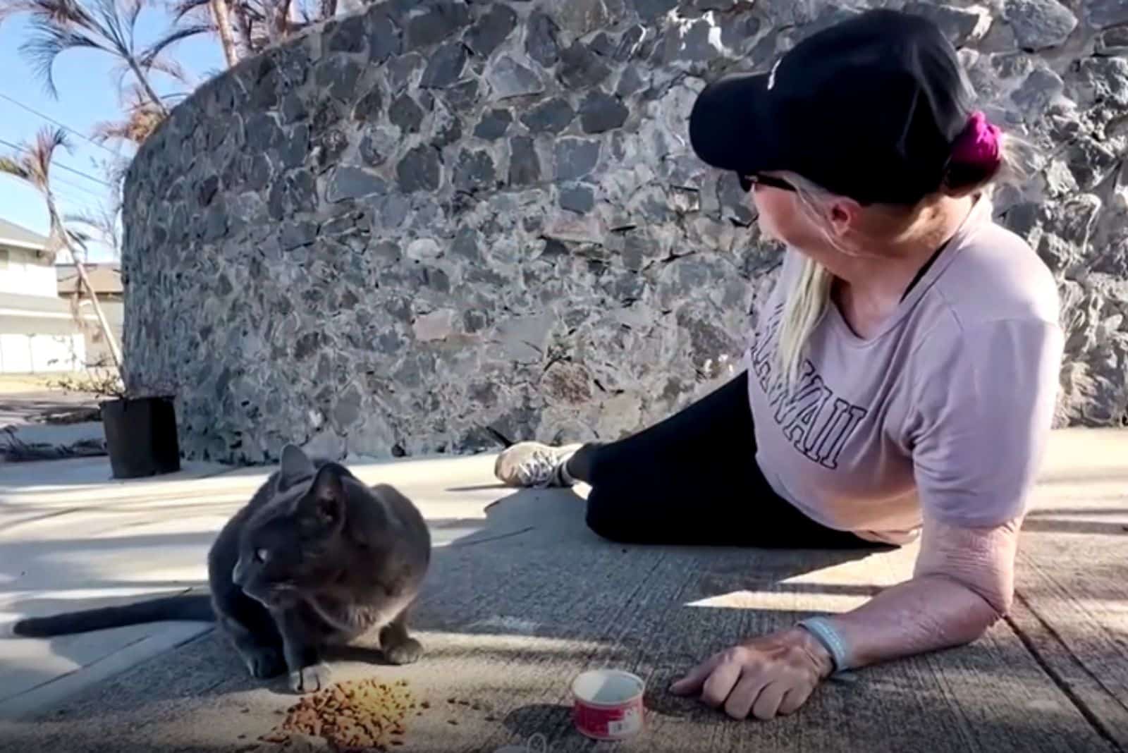 woman laying on the outdoor floor with cat