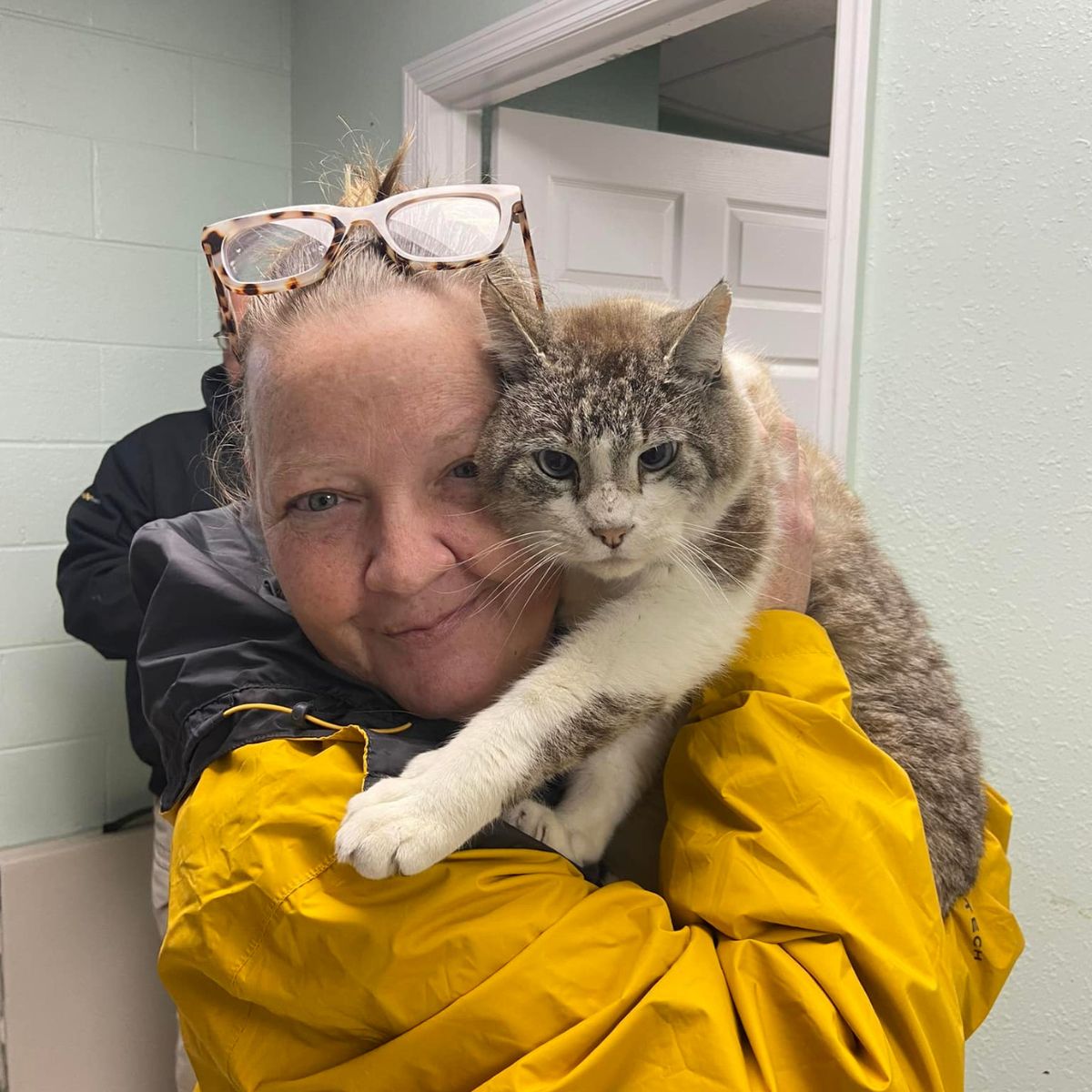 woman with glasses holding a cat