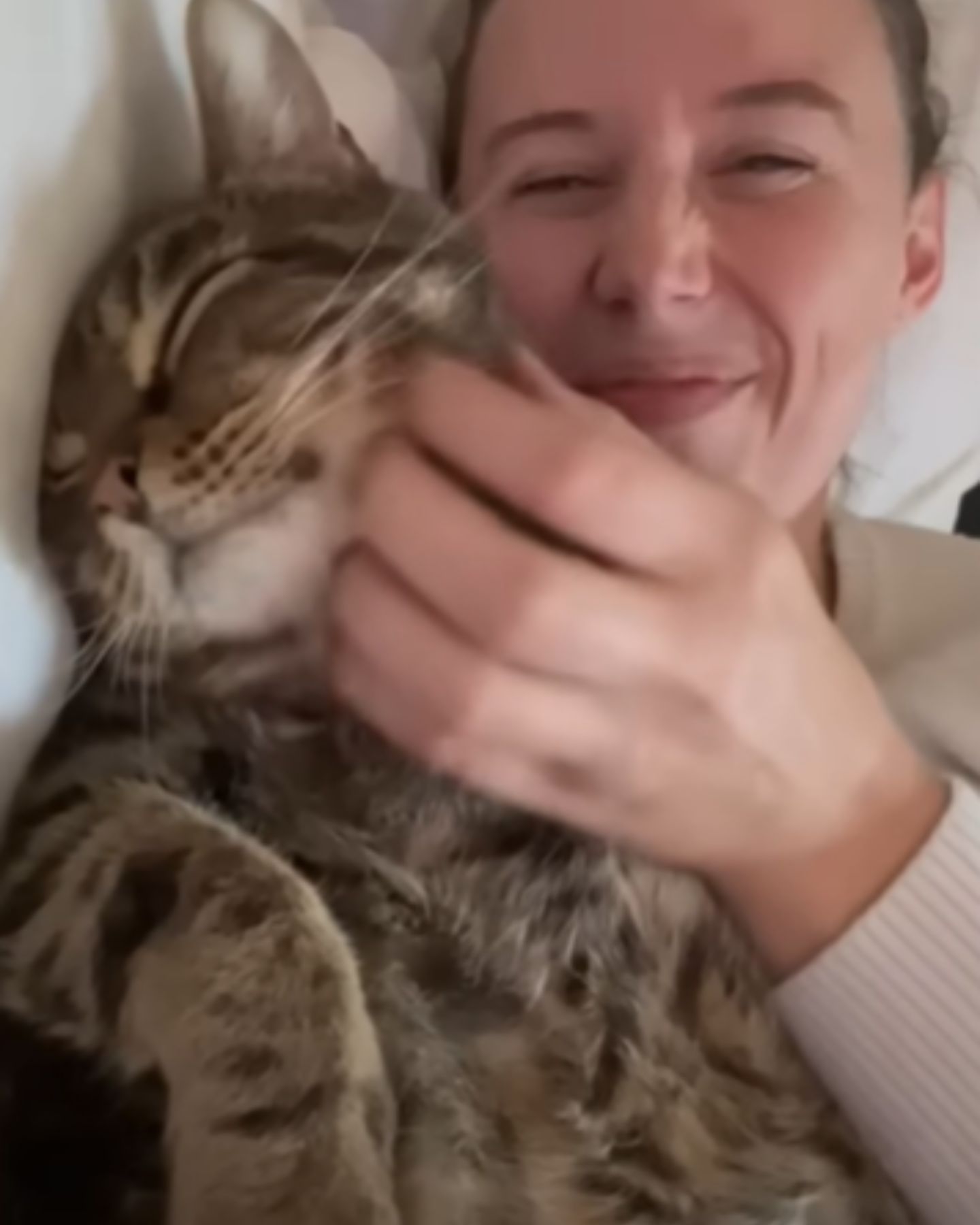 smiling woman lying with cat