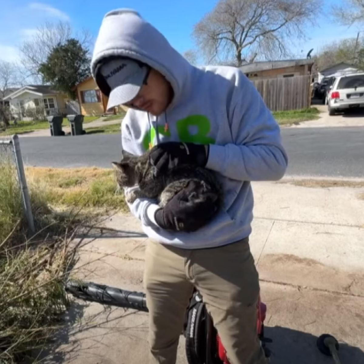 man in hoodie holding a cat