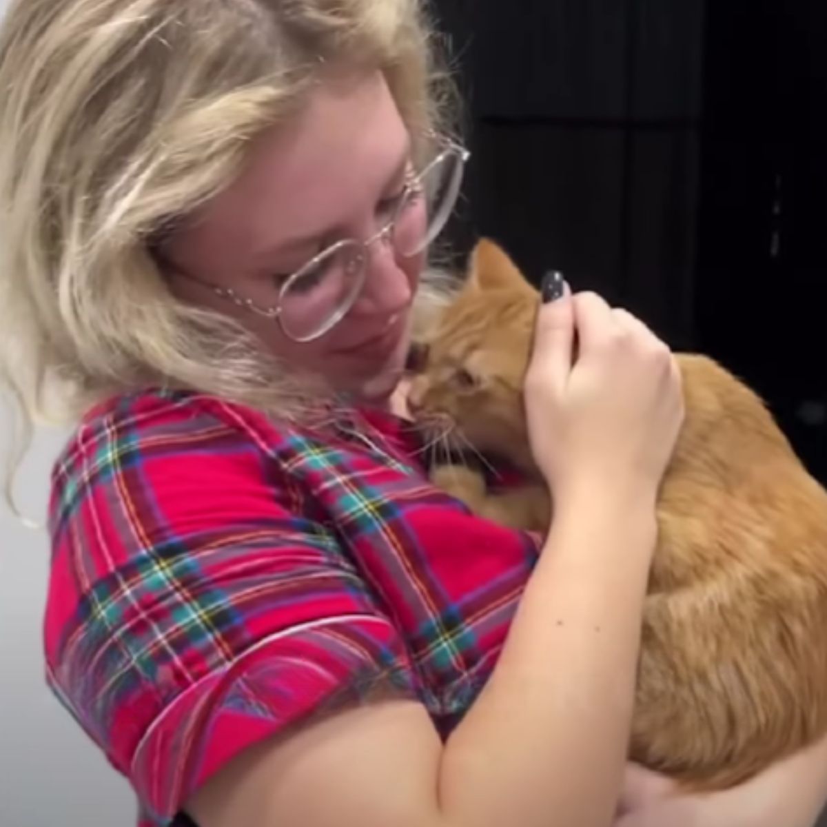 woman holding a ginger cat